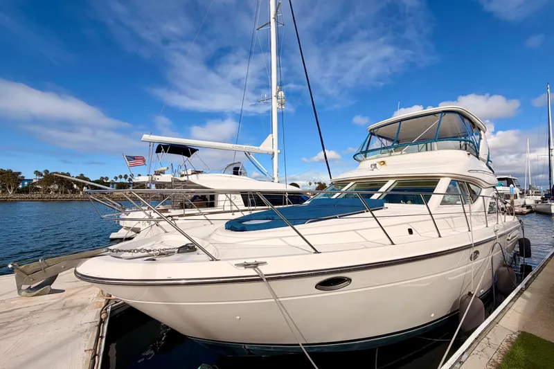 Slide: The Image of 2001 Maxum 4600 SCB Limited Edition yacht docked in a marina under blue skies. - 1