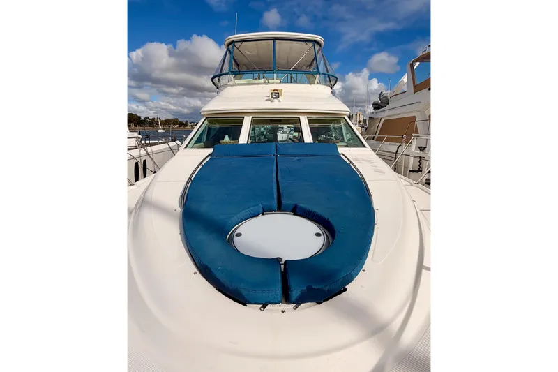 Slide: The Image of 2001 Maxum 4600 SCB Limited Edition yacht with blue sunpad, docked under a cloudy sky. - 19
