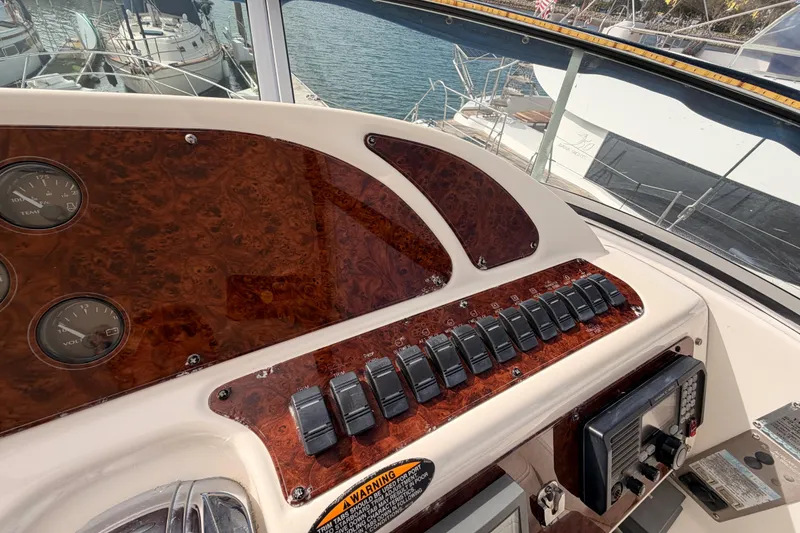 Slide: The Image of 2001 Maxum 4600 SCB Limited Edition yacht dashboard with wood paneling and control switches. - 34
