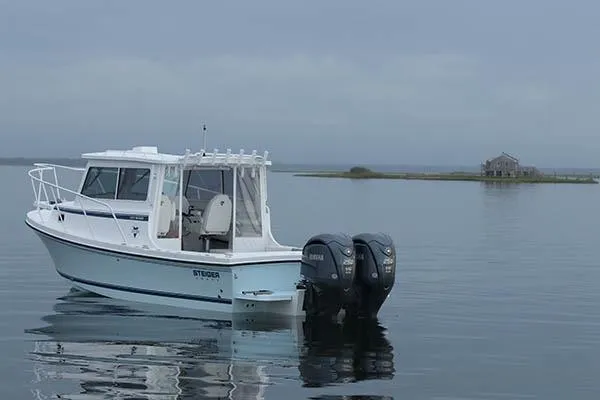 Slide: The Image of 2026 Steiger Craft 28 Fisherman boat on calm water with distant shoreline. - 1