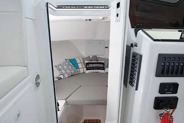 Slide: The Image of 2026 Steiger Craft 28 Fisherman cabin interior with cozy seating and nautical decor. - 5