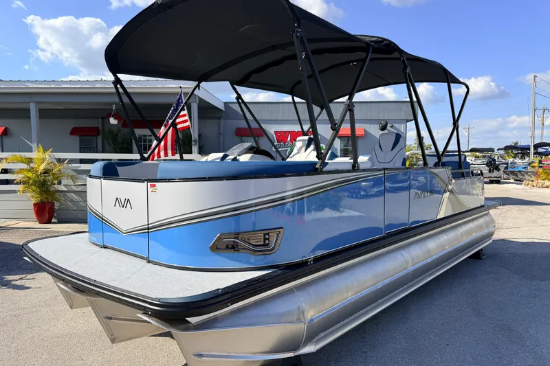 The Image of 2026 Avalon 2385 LSZ Quad Lounger Tri Toon boat with canopy, parked outdoors. - 1