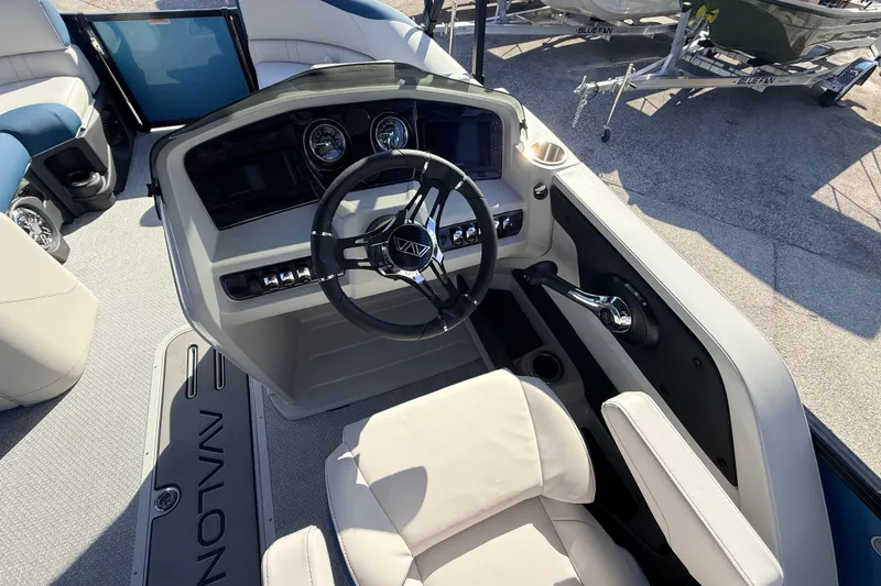 Slide: The Image of 2026 Avalon 2385 LSZ Quad Lounger boat interior with steering console and seating. - 25