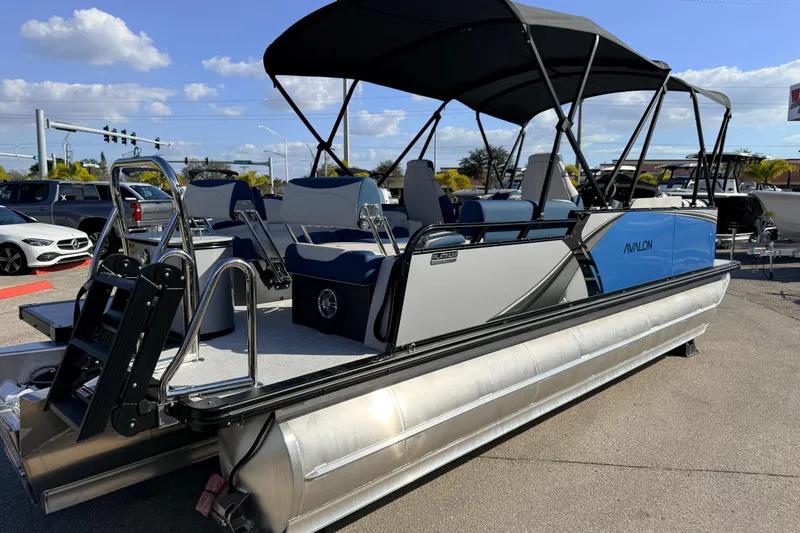 Slide: The Image of 2026 Avalon 2385 LSZ Quad Lounger Tri Toon boat with high performance features, parked outdoors. - 7