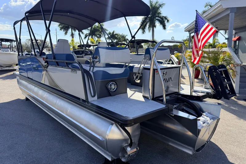 Slide: The Image of 2026 Avalon 2385 LSZ Quad Lounger Tri Toon boat with American flag, parked outdoors. - 9