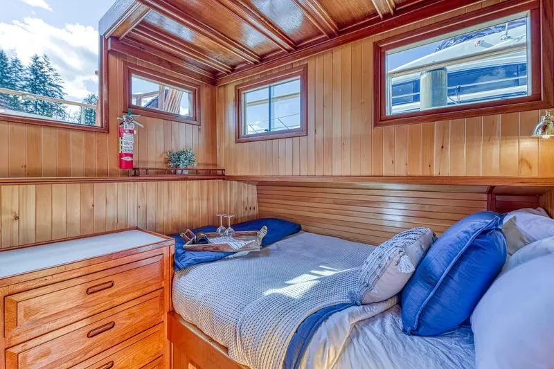 Slide: The Image of Cozy wooden cabin interior on 1981 Nielsen 46 boat, featuring a comfortable bed and natural light. - 11