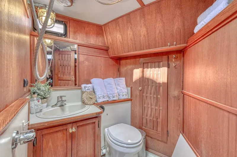 Slide: The Image of Wood-paneled boat bathroom with sink, toilet, and towels; Nielsen 46, 1981 model. - 12