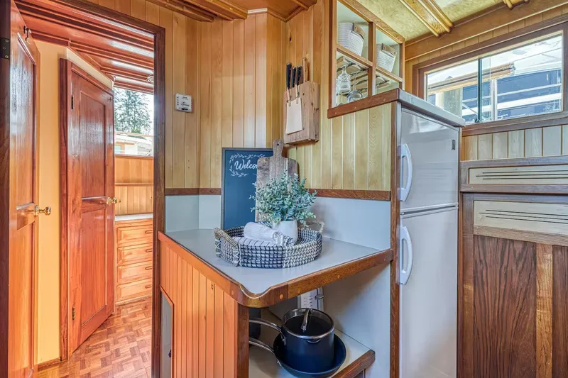 Slide: The Image of Cozy 1981 Nielsen 46 boat interior with wooden paneling and compact kitchen area. - 8