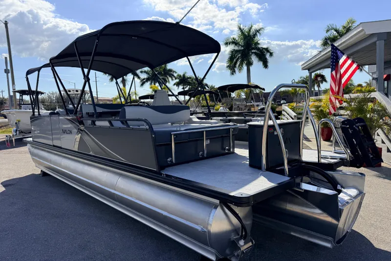 Slide: The Image of 2026 Avalon 2585 LSZ Entertainer Tri Toon boat with canopy, parked outdoors. - 11