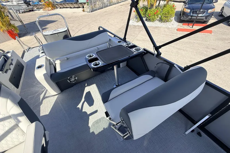Slide: The Image of 2026 Avalon 2585 LSZ Entertainer boat interior with seating and table, docked outdoors. - 22