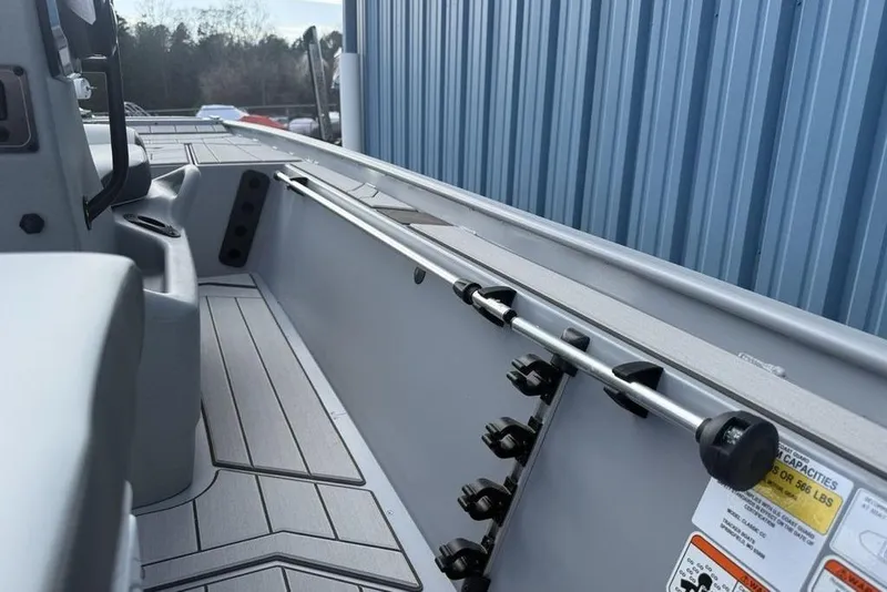 Slide: The Image of 2026 Tracker Bass Tracker Classic CC boat interior with rod holders and sleek design. - 21