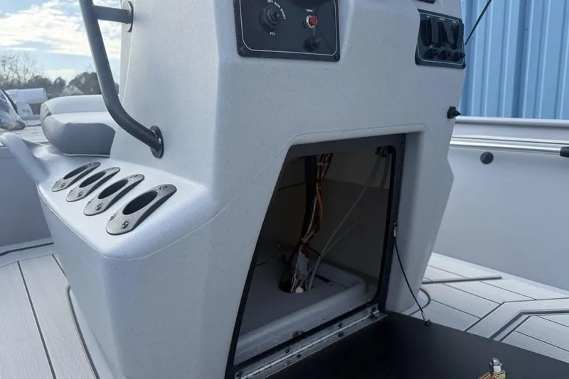 Slide: The Image of 2026 Tracker Bass Tracker Classic CC boat console with open storage compartment and rod holders. - 22