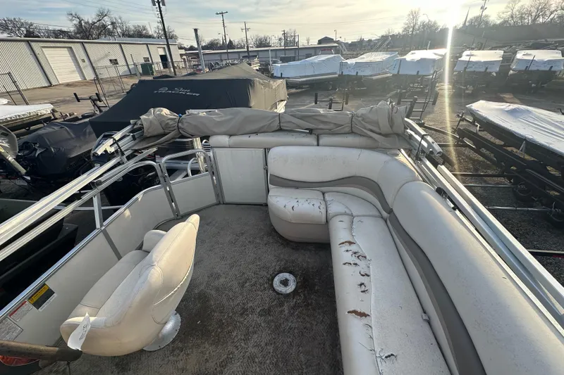 Slide: The Image of 2006 Sun Tracker Party Barge 21 Signature Series with worn seating in a boatyard. - 10