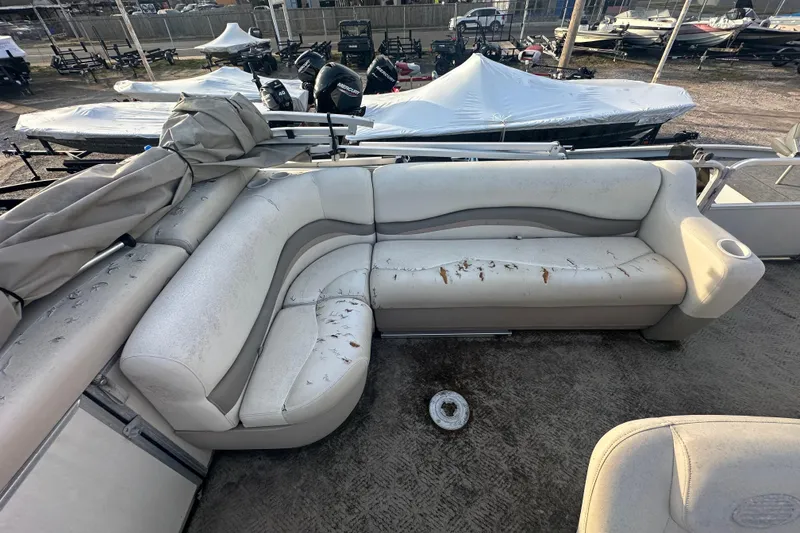 Slide: The Image of 2006 Sun Tracker Party Barge 21 Signature Series with worn seating and covered boats in background. - 12