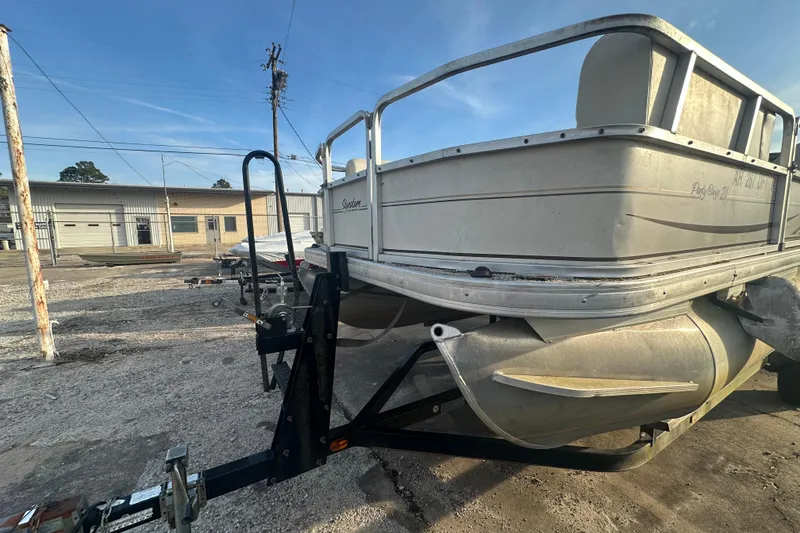 Slide: The Image of 2006 Sun Tracker Party Barge 21 Signature Series pontoon boat on trailer in storage yard. - 4