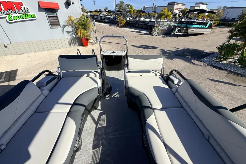Slide: The Image of 2026 Avalon 2385 LSZ Quad Lounger Tri Toon boat with luxurious seating at a marina. - 22