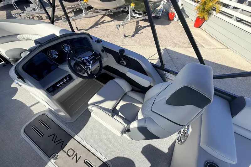 Slide: The Image of 2026 Avalon 2385 LSZ Quad Lounger boat interior with steering console and seating. - 23