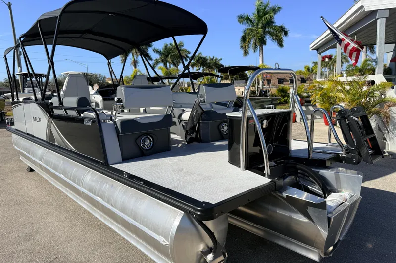 Slide: The Image of 2026 Avalon 2385 LSZ Quad Lounger Tri Toon boat with canopy, parked outdoors. - 8