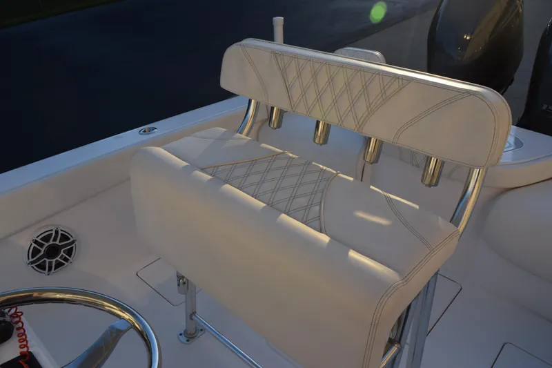 Slide: The Image of 2023 Contender 24 Sport boat interior with cushioned seating and steering wheel. - 11