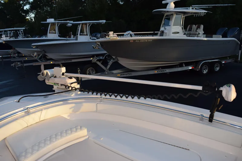 Slide: The Image of 2023 Contender 24 Sport boat with trolling motor, parked alongside other boats. - 14