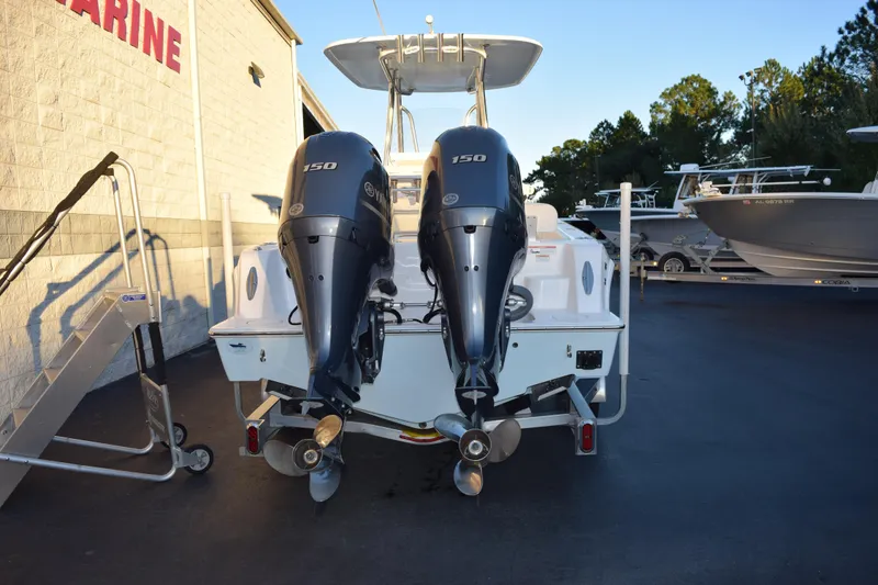 Slide: The Image of 2023 Contender 24 Sport boat with dual 150 horsepower engines, parked at a marina. - 5