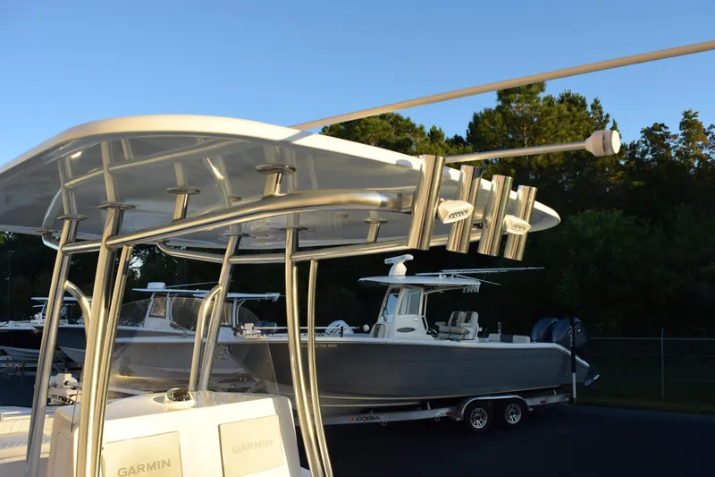Slide: The Image of 2023 Contender 24 Sport boat with T-top and rod holders, parked on a trailer. - 9