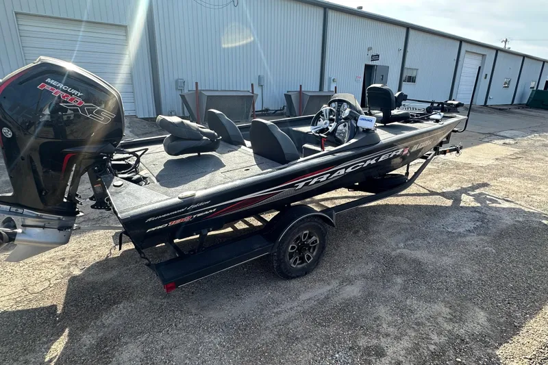 Slide: The Image of 2023 Tracker Pro Team 190 TX boat with Mercury engine, parked outdoors. - 11