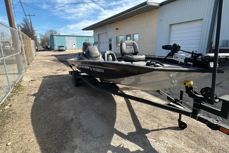 Slide: The Image of 2023 Tracker Pro Team 190 TX boat on trailer outside industrial building. - 2