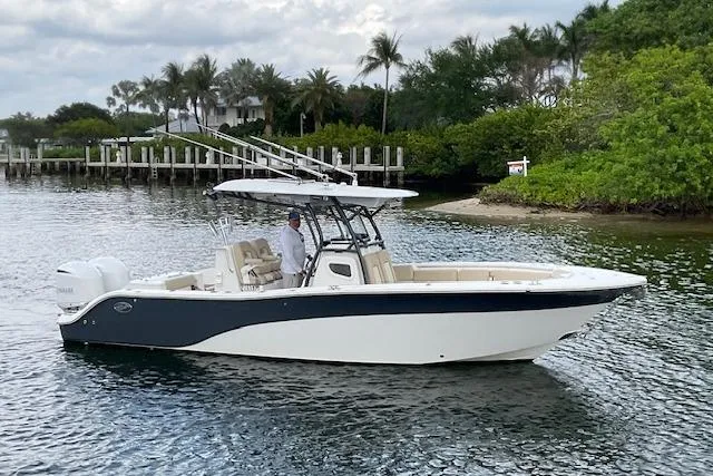 Slide: The Image of 2017 Sea Fox 288 Commander boat on calm water near lush shoreline. - 2