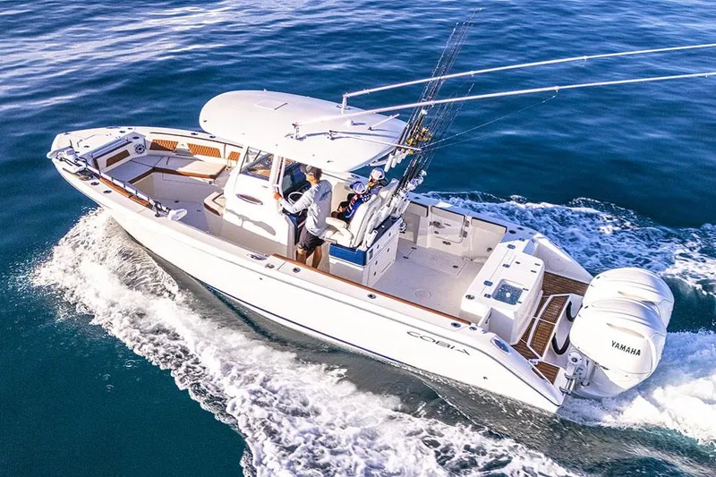 Slide: The Image of Manufacturer Provided Image: 2025 Cobia 285 Center Console boat cruising on open water, featuring Yamaha engines. - 1