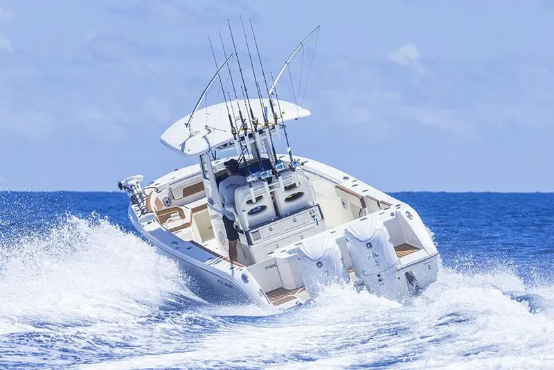 Slide: The Image of Manufacturer Provided Image: 2025 Cobia 285 Center Console boat navigating ocean waves, equipped for fishing. - 3