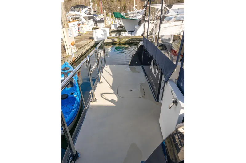 Slide: The Image of 2013 Coastal Craft 45 yacht deck at marina, featuring sleek design and stainless steel railings. - 6