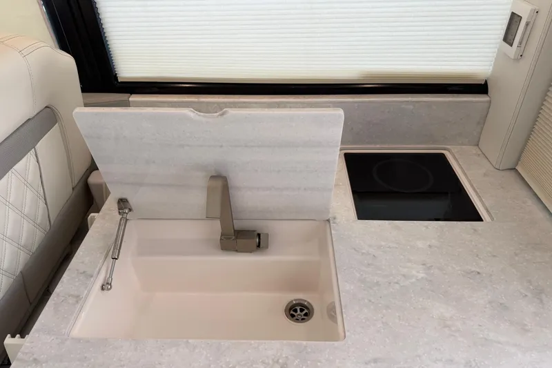 Slide: The Image of Modern kitchen area in 2021 Regal 36 XO yacht with sink and induction cooktop. - 19