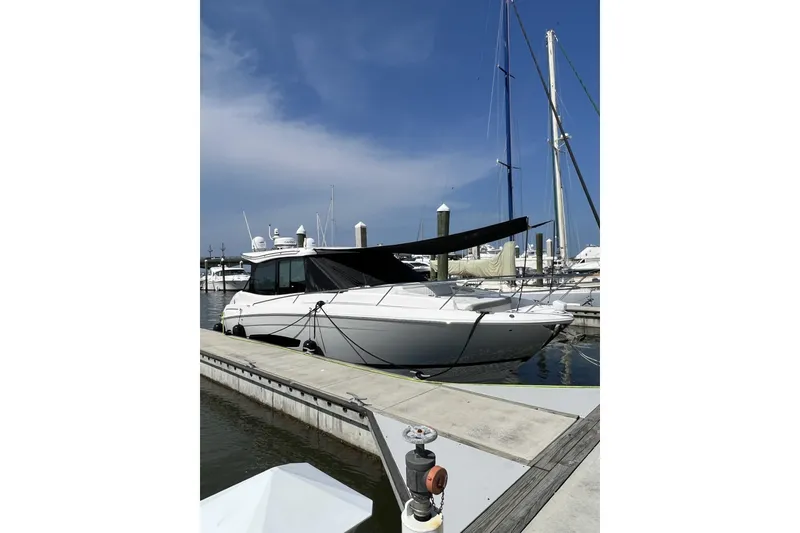 Slide: The Image of 2021 Regal 36 XO yacht docked at marina under clear blue sky. - 2