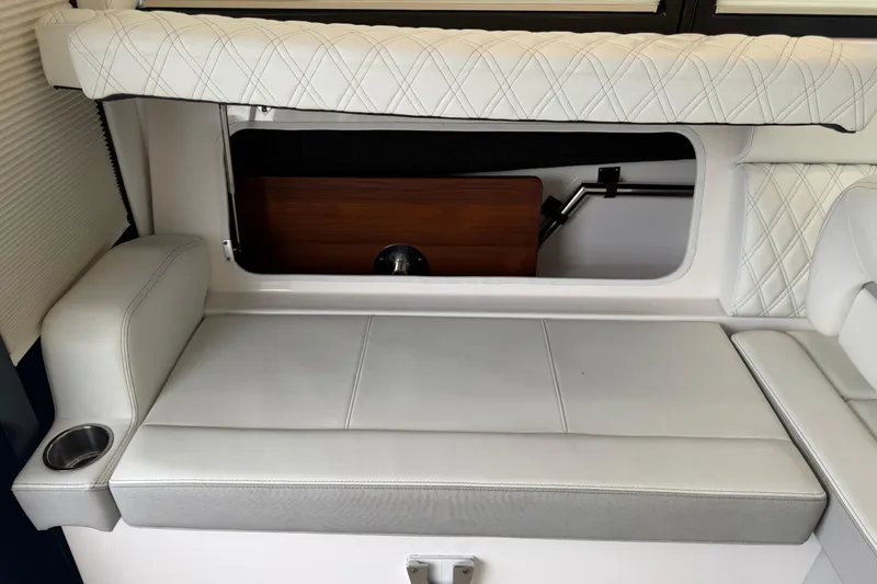 Slide: The Image of 2021 Regal 36 XO boat interior with white cushioned seating and cup holder. - 28