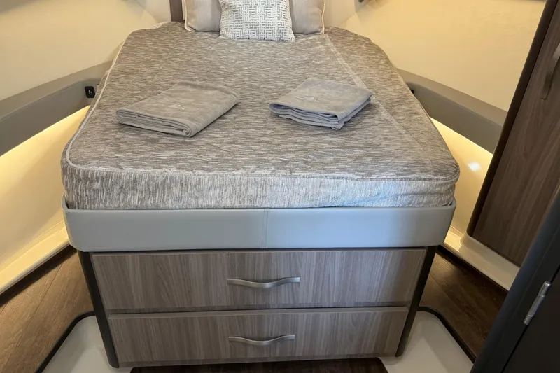 Slide: The Image of 2021 Regal 36 XO cabin interior with neatly made bed and folded towels. - 40