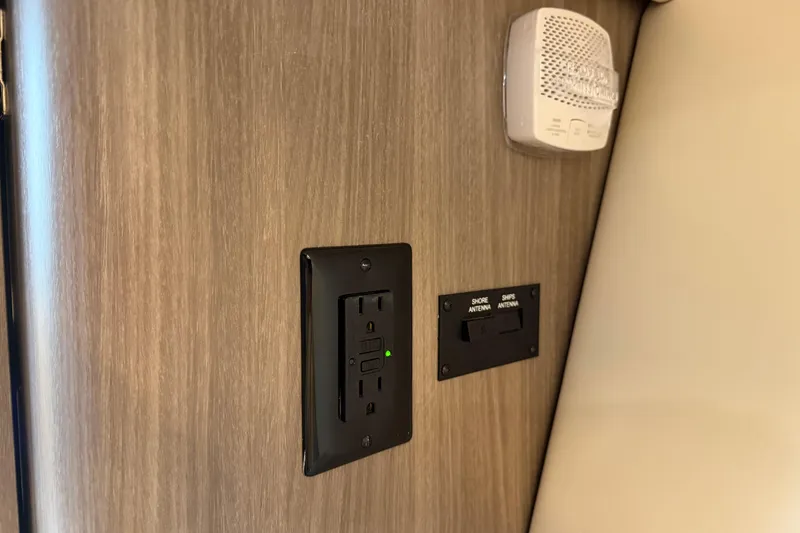 Slide: The Image of 2021 Regal 36 XO interior with power outlet and antenna switch on wooden panel. - 47