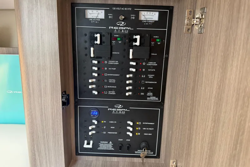 Slide: The Image of Electrical control panel of a 2021 Regal 36 XO boat, featuring various switches and gauges. - 48