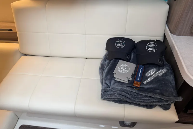 Slide: The Image of 2021 Regal 36 XO boat interior with branded merchandise on white seating. - 50