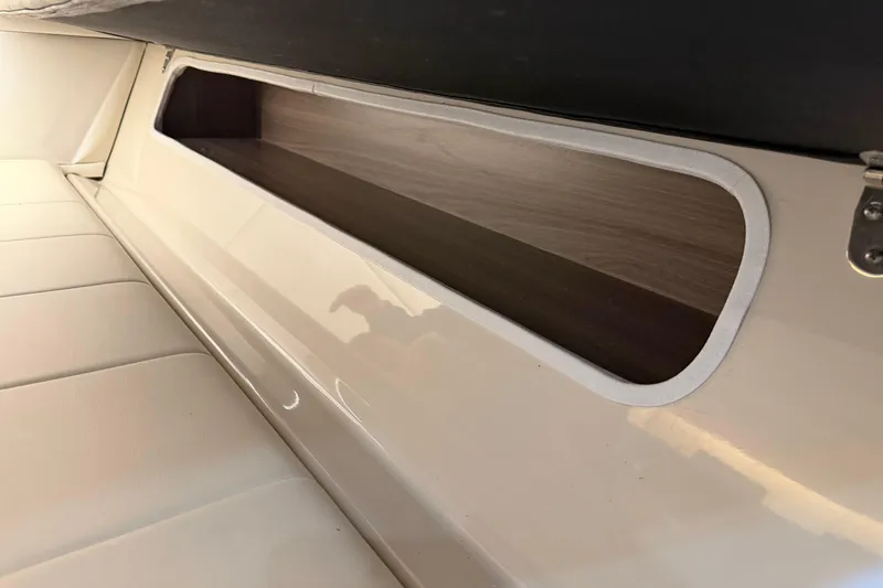 Slide: The Image of Interior storage compartment of 2021 Regal 36 XO boat, featuring sleek design and wood finish. - 52