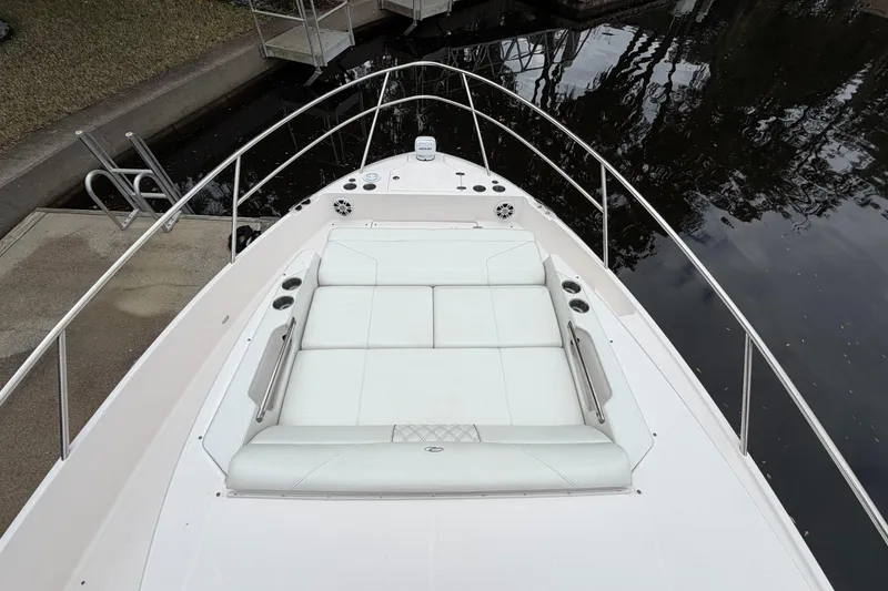 Slide: The Image of 2021 Regal 36 XO boat with spacious white deck seating by the water. - 58