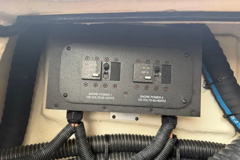 Slide: The Image of Electrical panel on a 2021 Regal 36 XO boat, featuring shore power connections. - 70