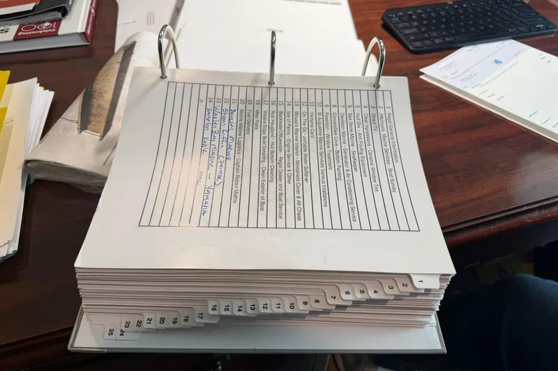 Slide: The Image of Binder with organized documents on a desk, featuring a Regal 36 XO 2021 manual. - 75