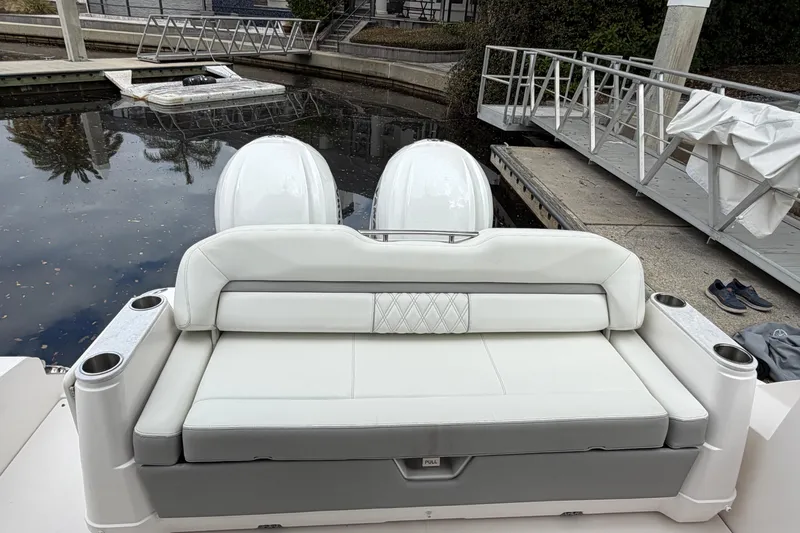 Slide: The Image of 2021 Regal 36 XO boat with white seating and dual outboard motors at a dock. - 9
