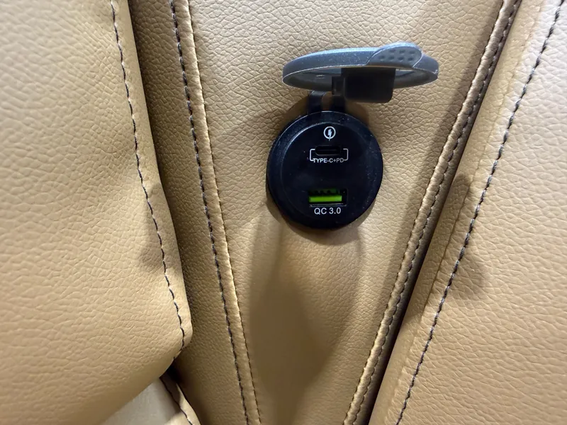 Slide: The Image of USB charging port on beige leather seat, Tahoe Pontoon 2026. - 30