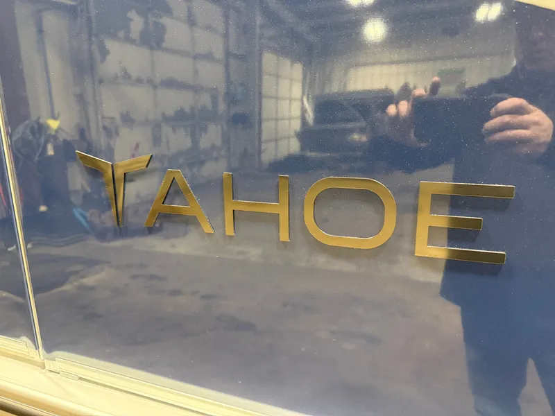 Slide: The Image of 2026 Tahoe LTZ 2385 Swingback Tritoon logo in a garage. - 44