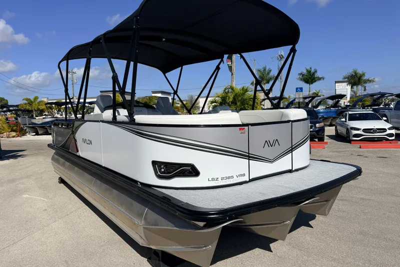 Slide: The Image of 2026 Avalon 2385 LSZ Versatile Rear Bench Tri Toon boat in a sunny outdoor setting. - 4