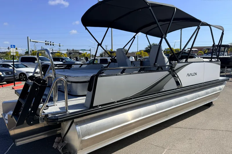 Slide: The Image of 2026 Avalon 2385 LSZ Versatile Rear Bench Tri Toon boat with canopy in parking lot. - 5