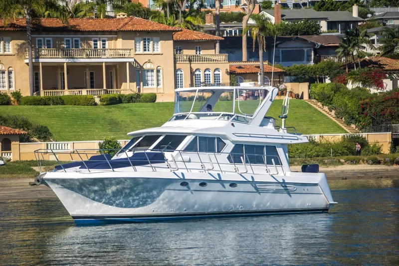 The Image of 2005 Navigator 4400 Pilothouse yacht cruising near luxury waterfront homes. - 0