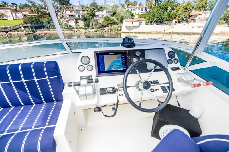 Slide: The Image of Pilothouse of 2005 Navigator 4400 with blue seating and navigation equipment, overlooking waterfront homes. - 13